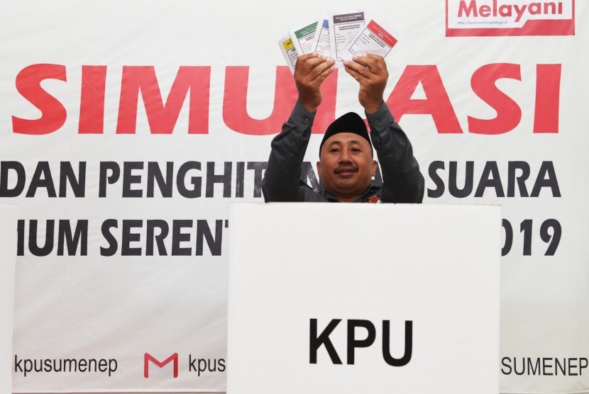 Seorang penyelenggara Pemilu 2019 menunjukkan kertas suara sebelum melakukan pencoblosan di bilik suara saat simulasi pemungutan dan perhitungan suara pemilihan umum 2019 di Sumenep, Jawa Timur, Sabtu (16/3).