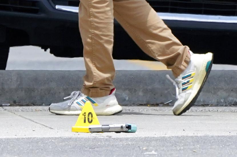 Seorang penyelidik berjalan melewati pistol dan penanda barang bukti di TKP penembakan di Universitas Xavier di New Orleans, Selasa, 31 Mei 2022. Penembakan massal terjadi  tidak lepas dari izin kepemilikan senjata yang memang begitu mudah di Amerika Serikat.