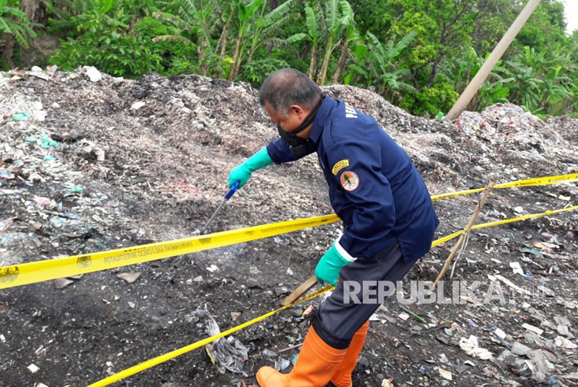 Seorang penyidik dari Gakkum KLHK sedang mengambil sampel limbah medis yang dibuang di tempat pembuangan sampah liar Desa Panguragan Wetan, Kamis (14/2).