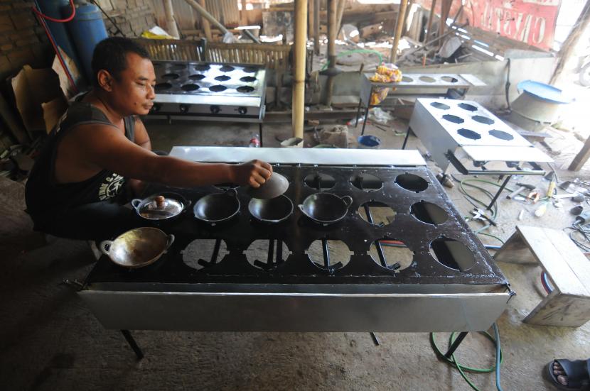 Seorang perajin memasang tutup wajan kue serabi saat membuat kompor serabi di Bakungan, Karangdowo, Klaten, Jawa Tengah, Rabu (29/9/2021). Menurut perajin, hasil pembuatan kompor kue serabi tersebut dipasarkan dengan memanfaatkan media sosial dan marketplace sehingga pemasaran lebih luas ke berbagai wilayah di Indonesia yang dijual dari harga Rp900 ribu hingga Rp3 juta tergantung jumlah tungku dan ukurannya.