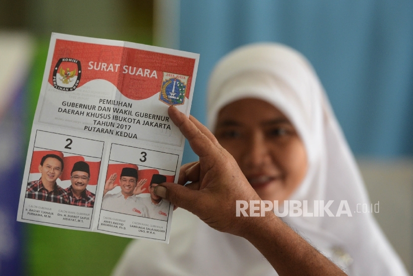 A nurse was taking a good look at ballot before voting in the second round of Jakarta gubernatorial election at polling station 15, Cipto Mangunkusumo Hospital (RSCM), Central Jakarta, Wednesday (April 19).
