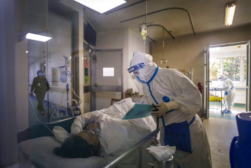 Seorang perawat mengecek kondisi pasien yang terjangkit virus corona.