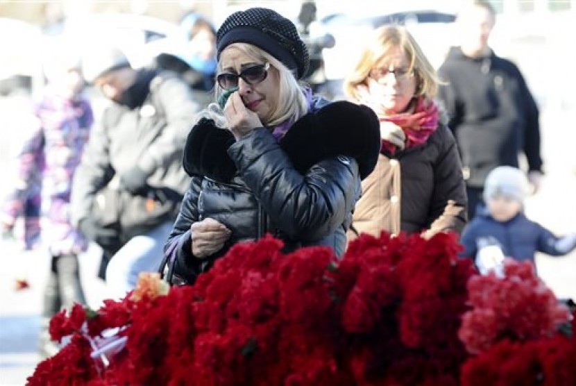 Seorang perempuan berduka setelah meletakkan bunga untuk menghormati korban jatuhnya pesawat FlyDubai di Bandara Rostov-on-Don di Moskow, Rusia, Ahad, 20 Maret 2016.