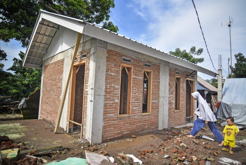 Seorang perempuan berjalan dekat bangunan Rumah Instan Sederhana Sehat (RISHA) untuk korban gempa di Desa Kekait, Kecamatan Gunungsari, Lombok Barat, NTB, Selasa (29/1/2019). 