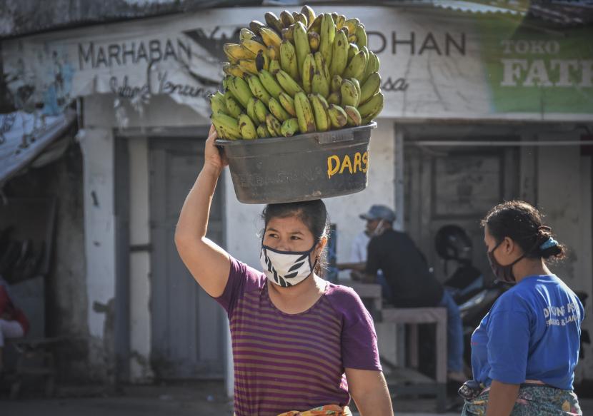 Seorang perempuan buruh panggul menggunakan masker saat bekerja di Pasar Tradisional ACC Ampenan, Mataram, NTB, Senin (11/5/2020). Menteri PPPA sebut banyak perempuan kehilangan penghasilan selama pandemi. Ilustrasi. 