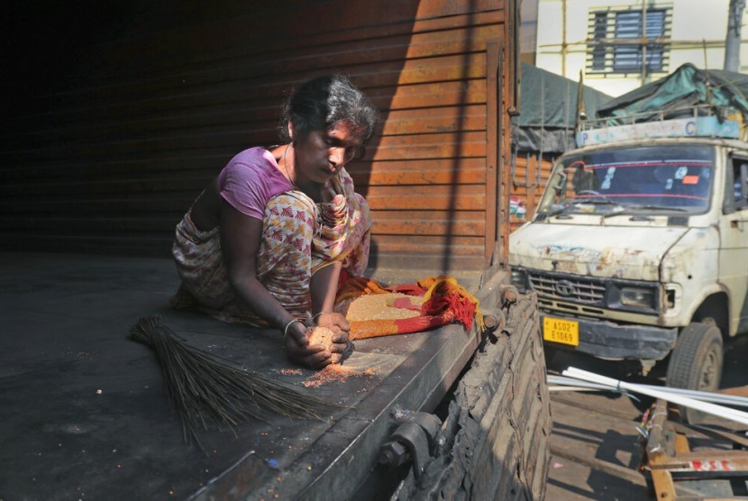 Seorang perempuan India mengumpulkan sisa kacang-kacangan dari sebuah truk sembako di Gauhati, India, Rabu (8/1). Laporan baru Oxfam menunjukkan ekonomi dunia memicu ketimpangan yang seksis.