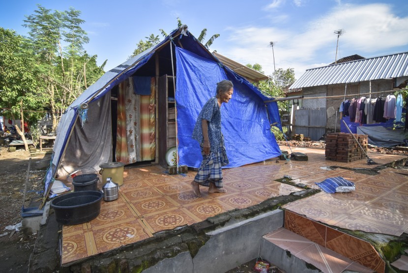 Seorang perempuan korban gempa berada dekat tenda yang dibangun diatas bekas rumahnya yang roboh akibat gempa di Desa Dopang, Kecamatan Gunungsari, Lombok Barat, NTB, Selasa (26/3/2019). 