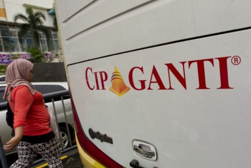 Seorang perempuan melintasi bus parwisata Cipaganti di Jakarta, Kamis (26/6). Tiga direksi perusahaan Cipaganti berinisial AS, DSR, dan YTS ditahan Polda Jabar terkait dugaan penggelapan dan penipuan koperasi Cipaganti kepada 8.700 mitra usahanya 