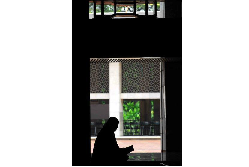 Seorang perempuan membaca kitab suci Alquran usai melaksanakan ibadah Shalat Dzuhur di Masjid Istiqlal, Jakarta, Senin (23/7). (Agung Supriyanto/Republika)