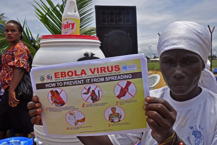 Seorang perempuan membawa selebaran yang berisi cara untuk mencegah penyebaran virus ebola di Monrovia, Liberia, Kamis (14/8).