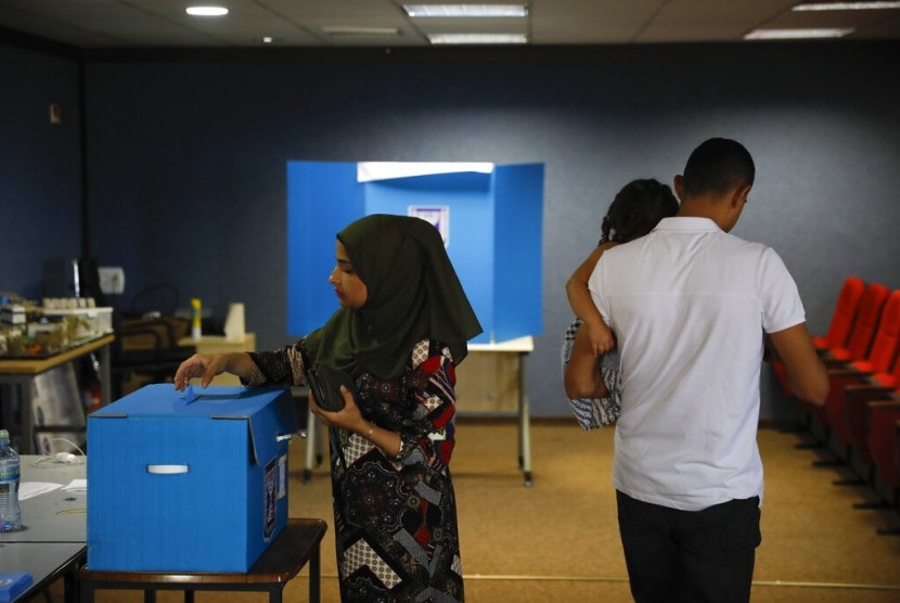 Seorang perempuan memberikan suaranya dalam pemilu di kota Arab Kfar Manda di Israel, Selasa (17/9).