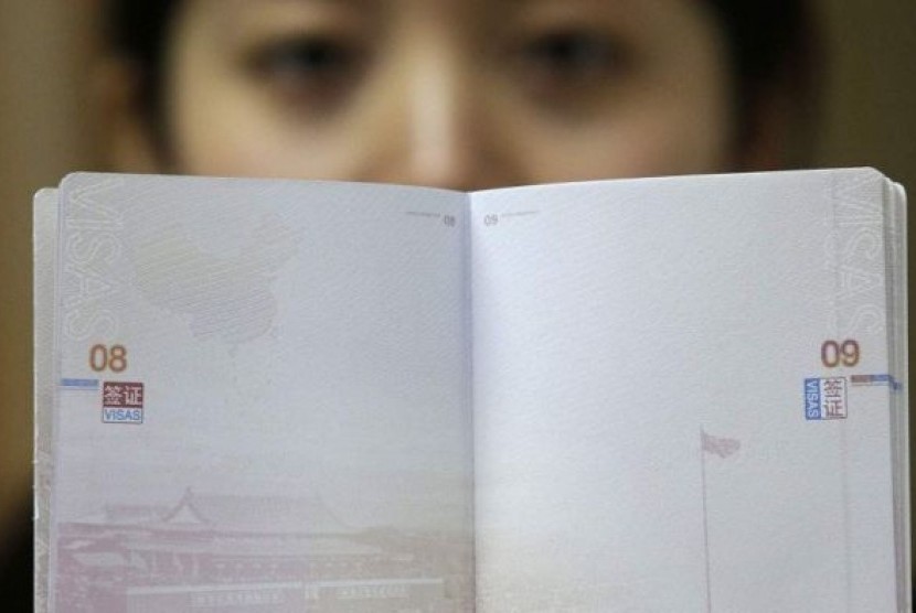  Seorang perempuan memegang paspor Cina tanpa visa.  