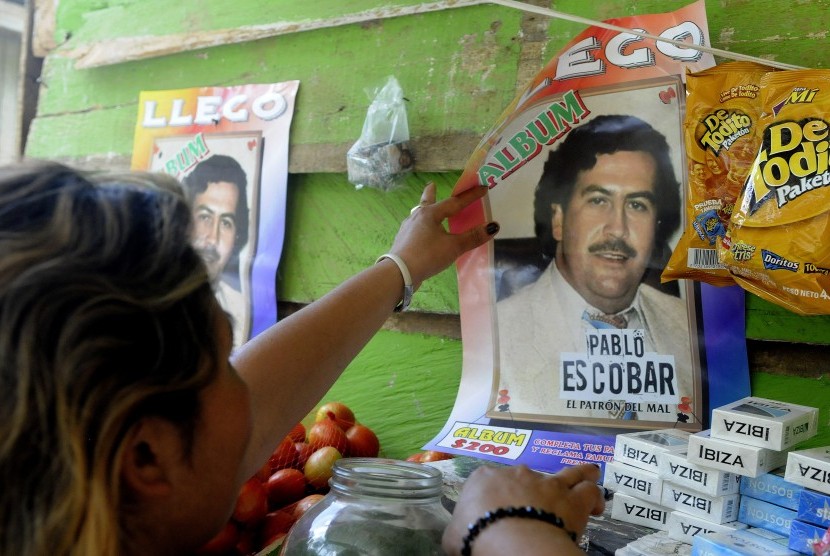 Seorang perempuan mencopot foto Pablo Escobar dari dinding di Kota Medelin, Kolombia, pada 2012.