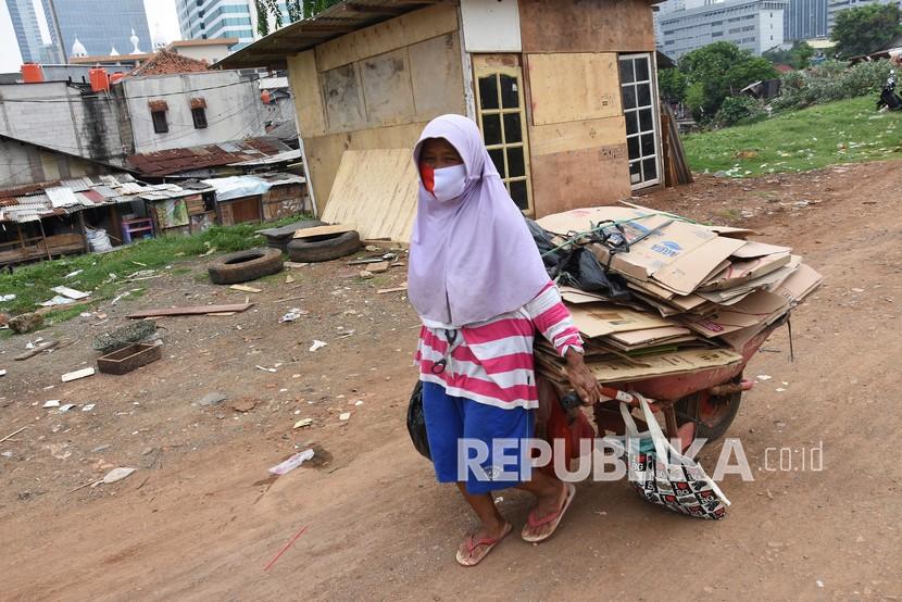 Seorang perempuan mengangkut tumpukan kardus di kawasan Menteng Pulo, Jakarta. (Ilustrasi)