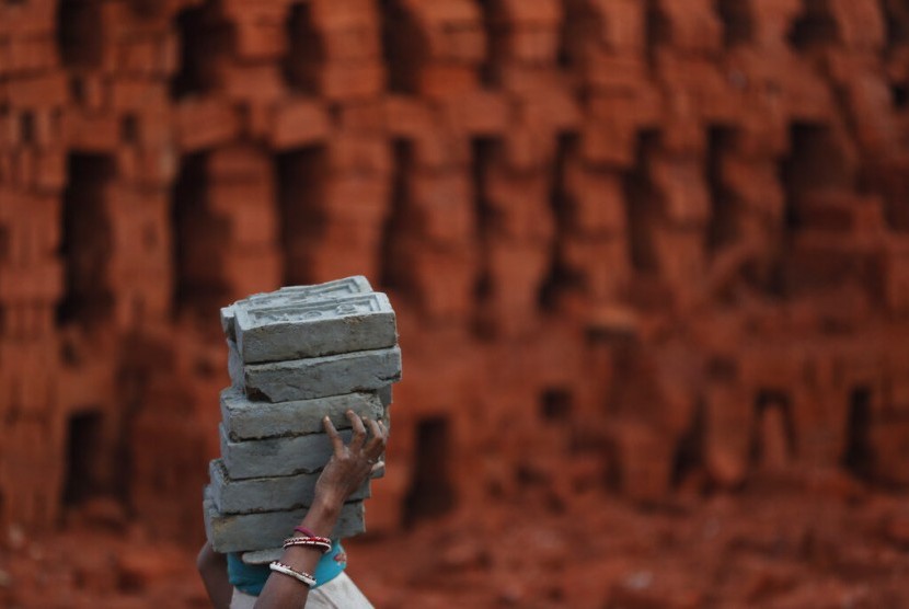 Seorang perempuan migran mengangkut batu bata di pabrik Kathmandu, Nepal, Kamis (9/1). Perempuan mendapatkan manfaat paling sedikit dari perekonomian dunia saat ini.