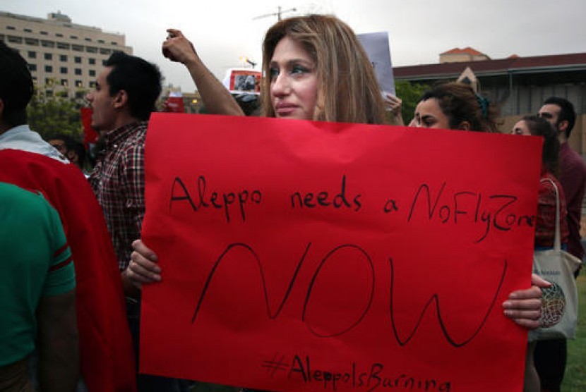 Seorang perempuan Suriah memegang poster dalam protes di markas PBB di Beirut, Lebanon, Ahad, 1 Mei 2016. Dia menentang operasi militer pemerintah Suriah di Aleppo.