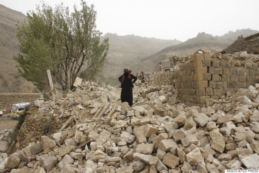 Seorang perempun Yaman berdiri di atas reruntuhan rumahnya di dekat Sanaa yang hancur akibat serangan koalisi Arab Saudi, 4 April 2015. 