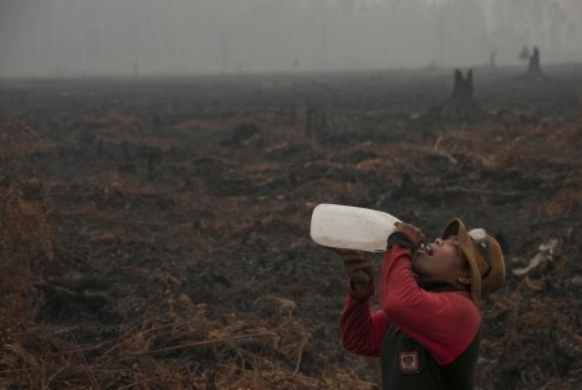 Seorang personel pemadam kebakaran Manggala Agni beristirahat saat melakukan pemadaman kebakaran di hutan Kawasan Suaka Margasatwa Kerumutan, Kabupaten Pelalawan, Riau, Rabu (28/10).