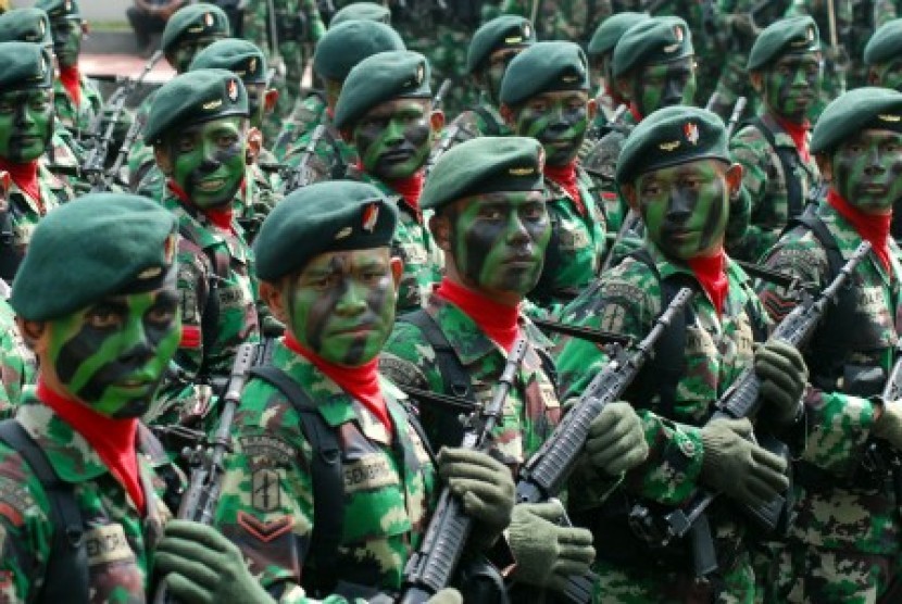 Seorang personil TNI AD menjelaskan peralatan persenjataan kepada sejumlah siswa saat sebuah pameran Alat Utama Sistem Persenjataan (Alutsista) TNI.