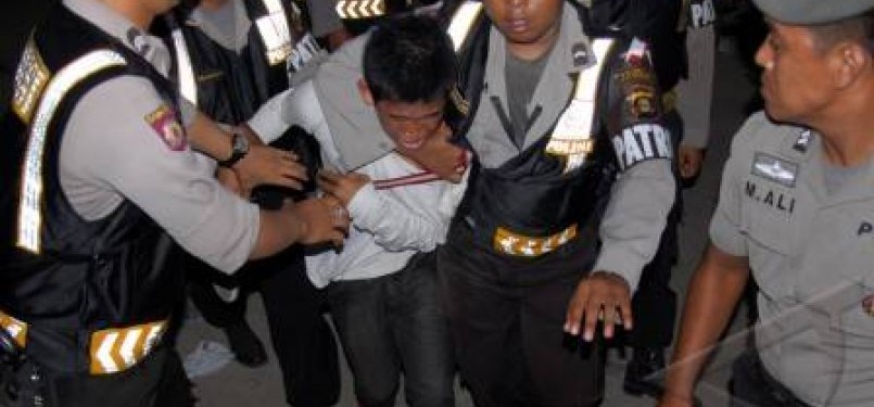 Seorang perusuh diamankan polisi saat terjadi kerusuhan di pintu masuk lokasi pembukaan SEA Games XXVI di kompleks Stadion Olahraga Sriwijaya, Jaka Baring, Palembang Sumsel, Jumat (11/11).