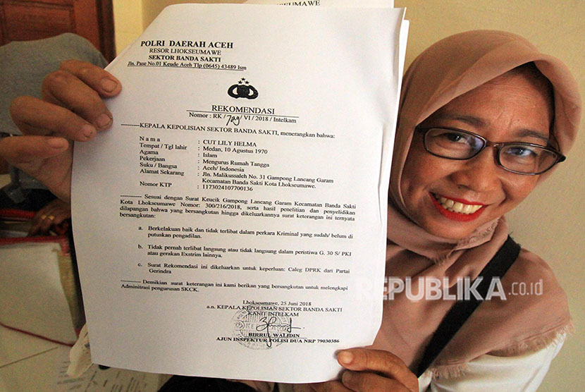 Seorang perwakilan perempuan bakal calon anggota legislatif (caleg) Pemilu 2019 menunjukkan surat rekomendasi dari Kepolisian saat pengurusan surat keterangan catatan kepolisian ( SKCK) di Polres Lhokseumawe, Aceh, Selasa (26/6). 