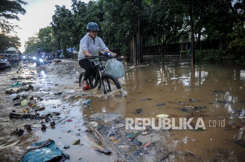 Seorang pesepeda menerjang banjir di kawasan Gedebage, Bandung. Hujan dengan intensitas tinggi di berbagai titik di Kota Bandung membuat sejumlah wilayah tergenang air yang menyebabkan kemacetan di jalan nasional Soekarno-Hatta. 