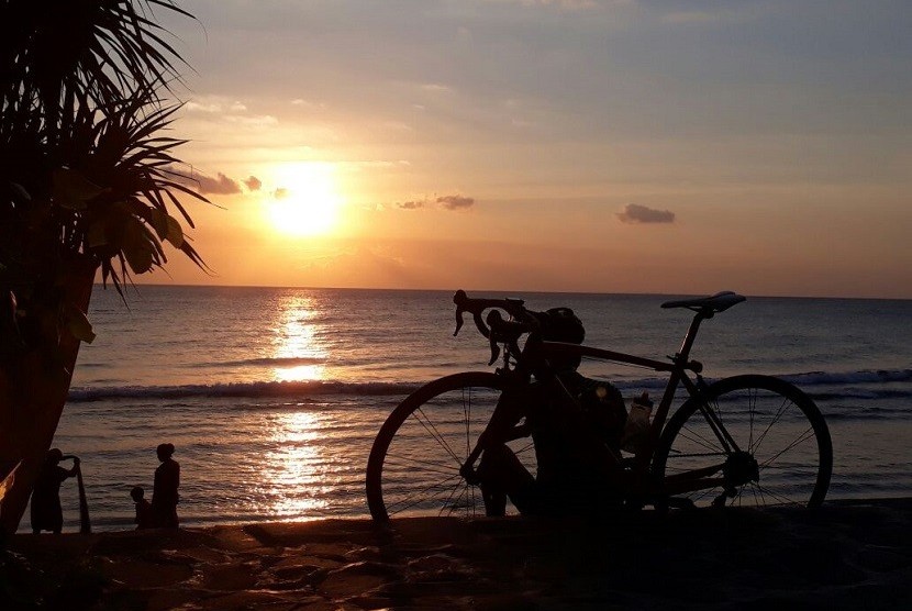 Seorang peserta Grand Fondo New York (GFNY) sedang menikmati matahari terbenam di Pantai Senggigi pada Sabtu (2/9). Dijadwalkan, 800 pembalap, baik dalam dan luar negeri akan mengikuti gowes lintas alam sepanjang 160 Km di Lombok, Nusa Tenggara Barat (NTB) pada Ahad (3/9).