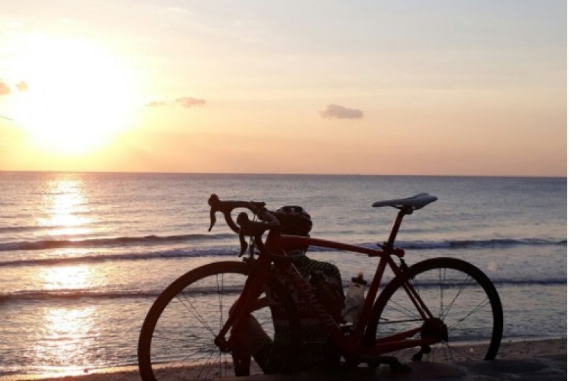 Seorang peserta Grand Fondo New York (GFNY) sedang menikmati matahari terbenam di Pantai Senggigi pada Sabtu (2/9). Sebanyak 800 pembalap, baik dalam dan luar negeri mengikuti gowes lintas alam sepanjang 160 Km di Lombok, Nusa Tenggara Barat (NTB) pada Ahad (3/9).