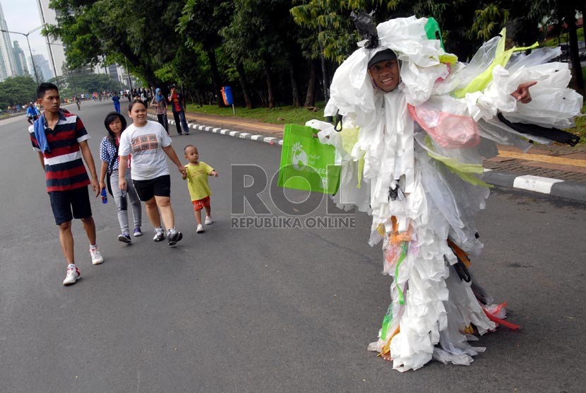 Seorang peserta kampanye memberikan sosialisasi pengurangan sampah kantong plastik kepada warga yang melintas di Jalan Jenderal Sudirman, Jakarta, Ahad (24/2).  (Republika/Agung Fatma Putra)