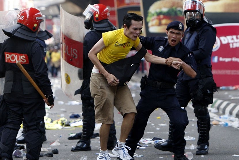   Seorang peseta aksi unjuk rasa ditahan oleh polisi di Kuala Lumpur, Malaysia, Sabtu (28/4).  (Mark Baker/AP)
