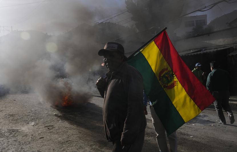 Seorang warga membawa bendera Bolivia (ilustrasi). 