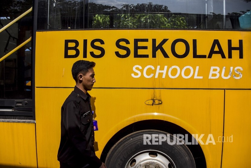 Seorang petugas beraktivitas di antara bus sekolah yang terparkir di Balai Pengujian Kendaraan Dinas Perhubungan, Gedebage, Kota Bandung, Rabu (16/10).