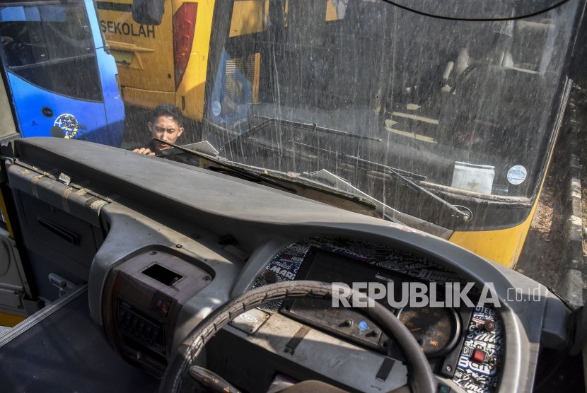 Seorang petugas beraktivitas di antara bus sekolah yang terparkir di Balai Pengujian Kendaraan Dinas Perhubungan, Gedebage, Kota Bandung, Rabu (16/10). Sebanyak tujuh unit bus sekolah mulai beroperasi di masa pembelajaran tatap muka (PTM) terbatas di masa pandemi Covid-19 yang digelar hari ini, Rabu (8/9).