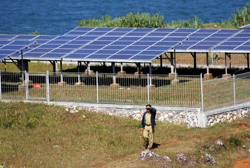 Seorang petugas berjalan di dekat pembangkit listrik tenaga surya di Balong Technopark, Kawasan Pantai Baron, Gunungkidul, Yogyakarta, Selasa (5/6).