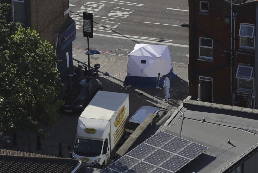 Seorang petugas forensik sedang memeriksa sebuah mobil van di dekat stasiun Finsbury Park setelah kendaraan tersebut menghantam pejalan kaki di London utara, Senin (19/6).