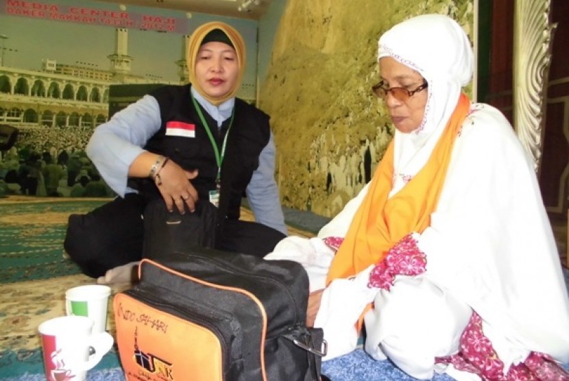 Seorang petugas haji Indonesia daerah kerja Makkah sedang melayani jamaah haji khusus yang tersesat di Masjidil Haram.