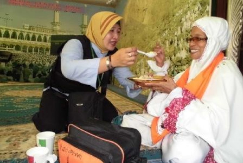 Seorang petugas haji Indonesia daerah kerja Makkah sedang melayani jamaah haji khusus yang tersesat di Masjidil Haram.