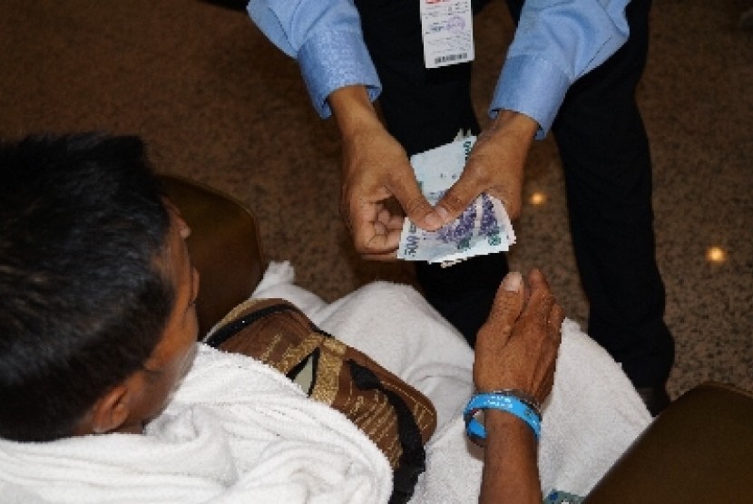 Seorang petugas haji Indonesia sedang membantu menghitung uang milik jamaah yang tersesat di Sektor X wilayah Bakhutmah. Jamaah tersebut membawa uang yang terlalu banyak. Petugas meminta agar jamaah tak membawa uang terlalu banyak saat beribadah, karena ra