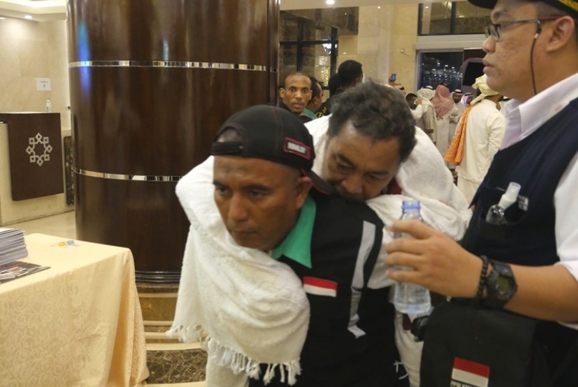 Seorang petugas haji menggendong jamaah risti saat tiba dari Madinah ke Makkah, Kamis (10/8)
