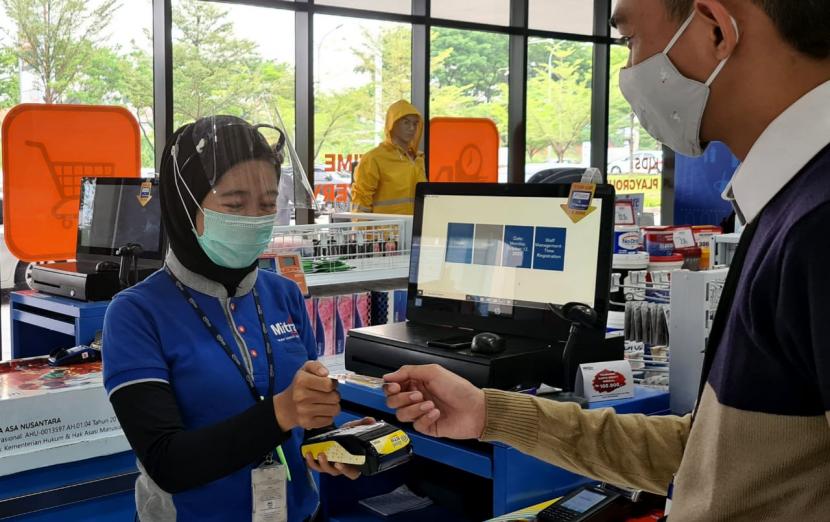 Seorang petugas kasir sedang melayani pembayaran melalui Electronic Data Capture (EDC) salah satu pelanggan usai berbelanja di Mitra 10, di Jakarta, Kamis (15/10).