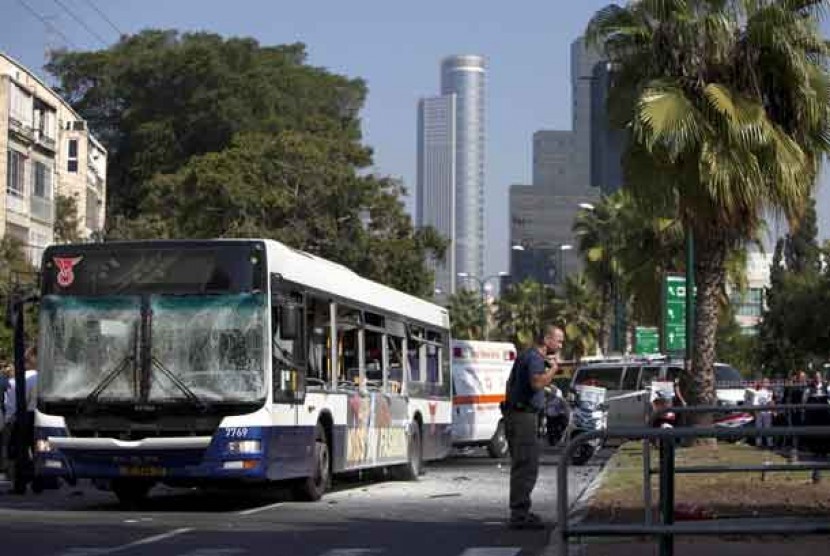 Seorang petugas keamanan Israel berdiri di samping bus di lokasi serangan bom di Tel Aviv,Israel,Rabu (21/11).