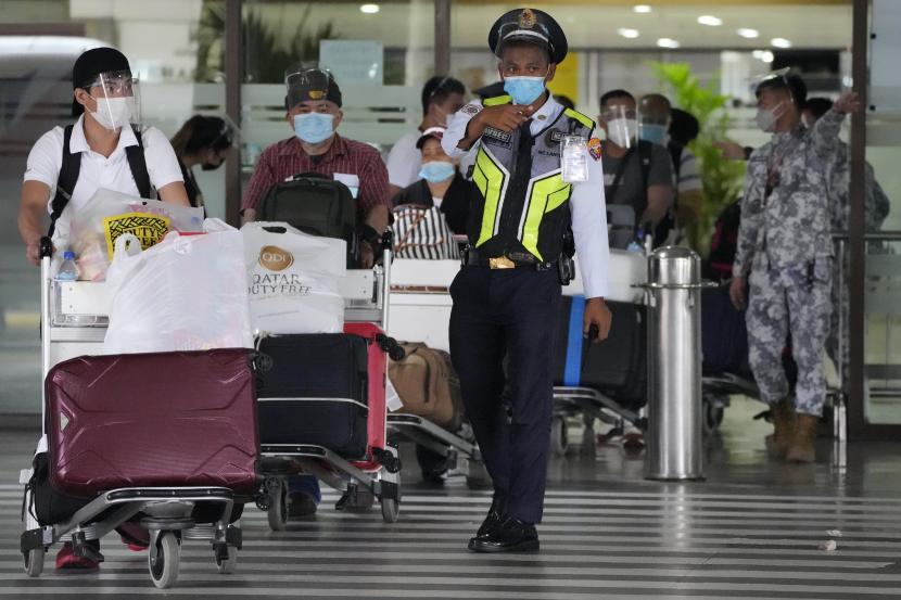Seorang petugas keamanan membantu penumpang saat mereka tiba di Bandara Internasional Manila, Filipina, beberapa waktu lalu.