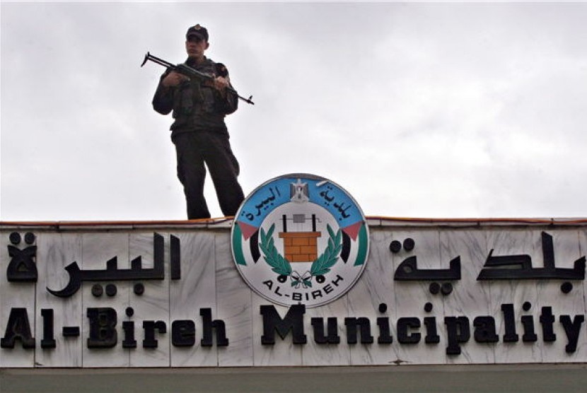 Seorang petugas keamanan Palestina menjaga kantor pemerintahan kota Bireh, Ramallah, Palestina. (ilustrasi) 