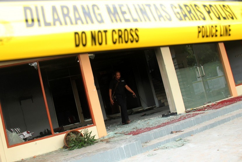 Seorang petugas kepolisian berada di lokasi bekas kebakaran kantor DPRD Kabupaten Gowa, Sulawesi Selatan, Selasa (27/9). 