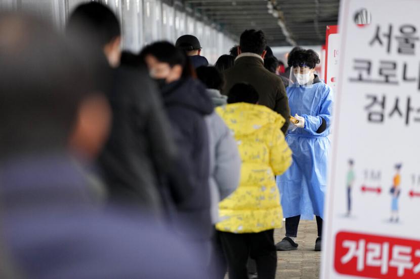 Seorang petugas kesehatan melayani pengunjung di klinik pemeriksaan untuk virus corona di Seoul, Korea Selatan, Selasa (25/1/2022).