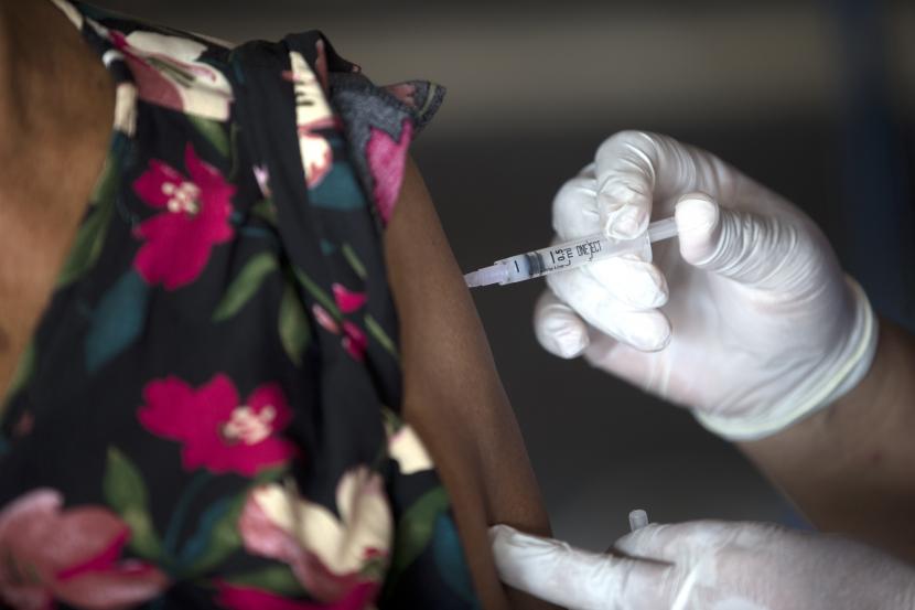 Seorang petugas kesehatan memberikan suntikan booster Moderna COVID-19 kepada seorang wanita lanjut usia saat kampanye vaksinasi dosis ketiga di Denpasar, Bali, Indonesia, Sabtu, 29 Januari 2022. 