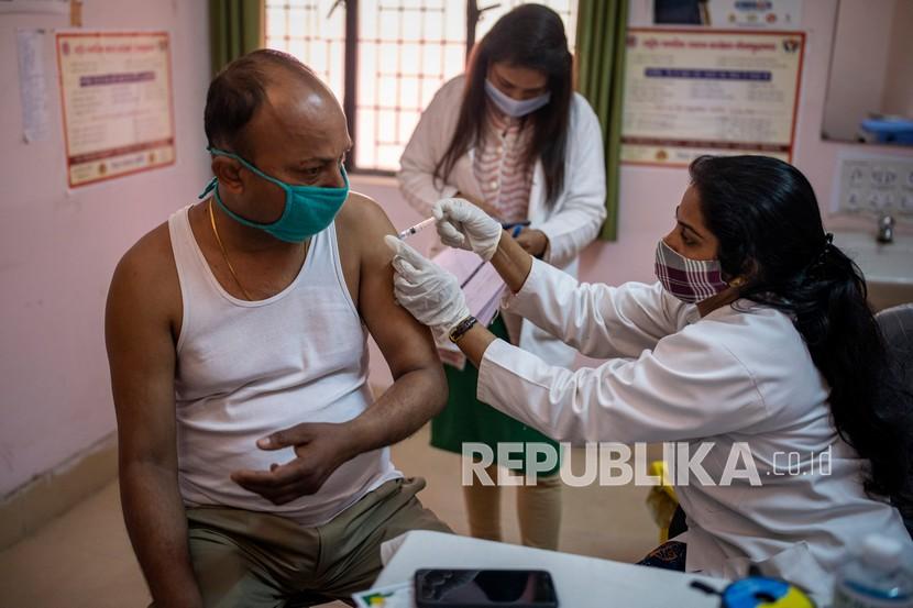  Seorang petugas kesehatan memberikan vaksin COVID-19 kepada petugas polisi di sebuah pusat kesehatan di Greater Noida, pinggiran kota New Delhi, India. Kasus Covid-19 di India kembali mengalami kenaikan.