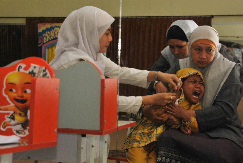 Seorang petugas kesehatan memberikan vaksin Difteri di PAUD Yasmin Fakultas Keguruan Dan Ilmu Pendidikan Universitas Muhammadiyah Jember, Jawa Timur.