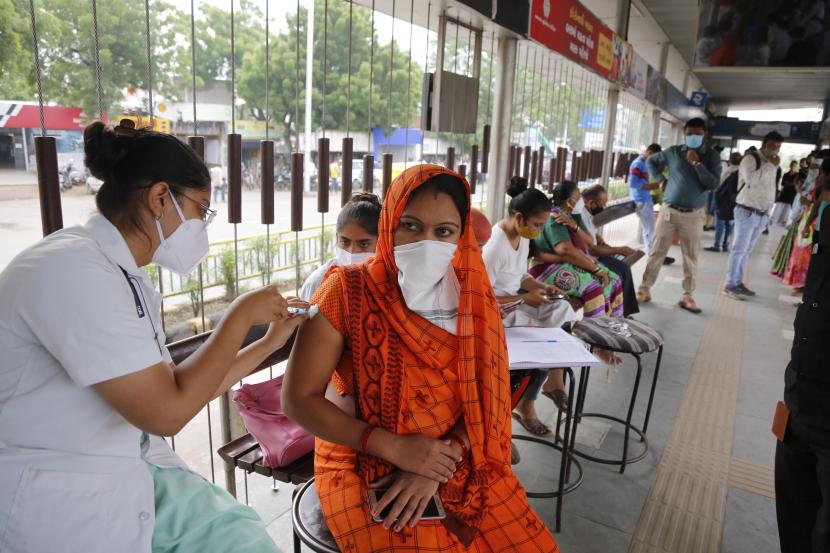Seorang petugas kesehatan memberikan vaksin untuk COVID-19 selama perjalanan vaksinasi khusus oleh perusahaan kota di halte bus di Ahmedabad, India, Jumat, 17 September 2021.