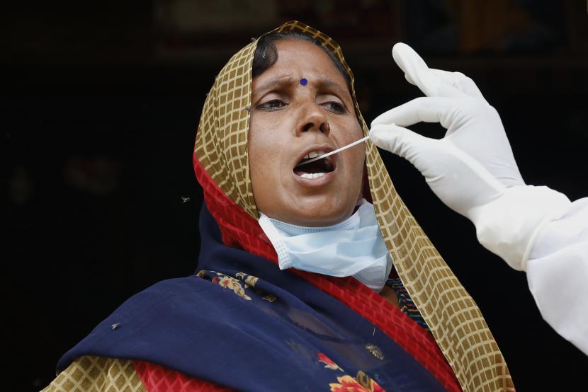 Seorang petugas kesehatan mengambil sampel usap seorang wanita untuk diuji COVID-19 di desa Kusehta utara Prayagraj, India, Sabtu, 29 Mei 2021. 
